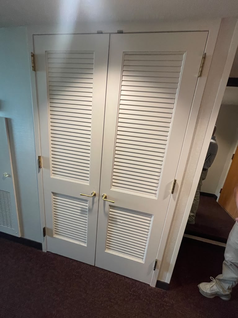Louvered closet doors with brass lever hardware, included with the package