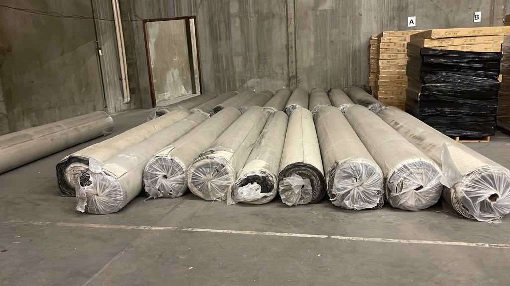 Rolls of brand-new carpet staged in the warehouse