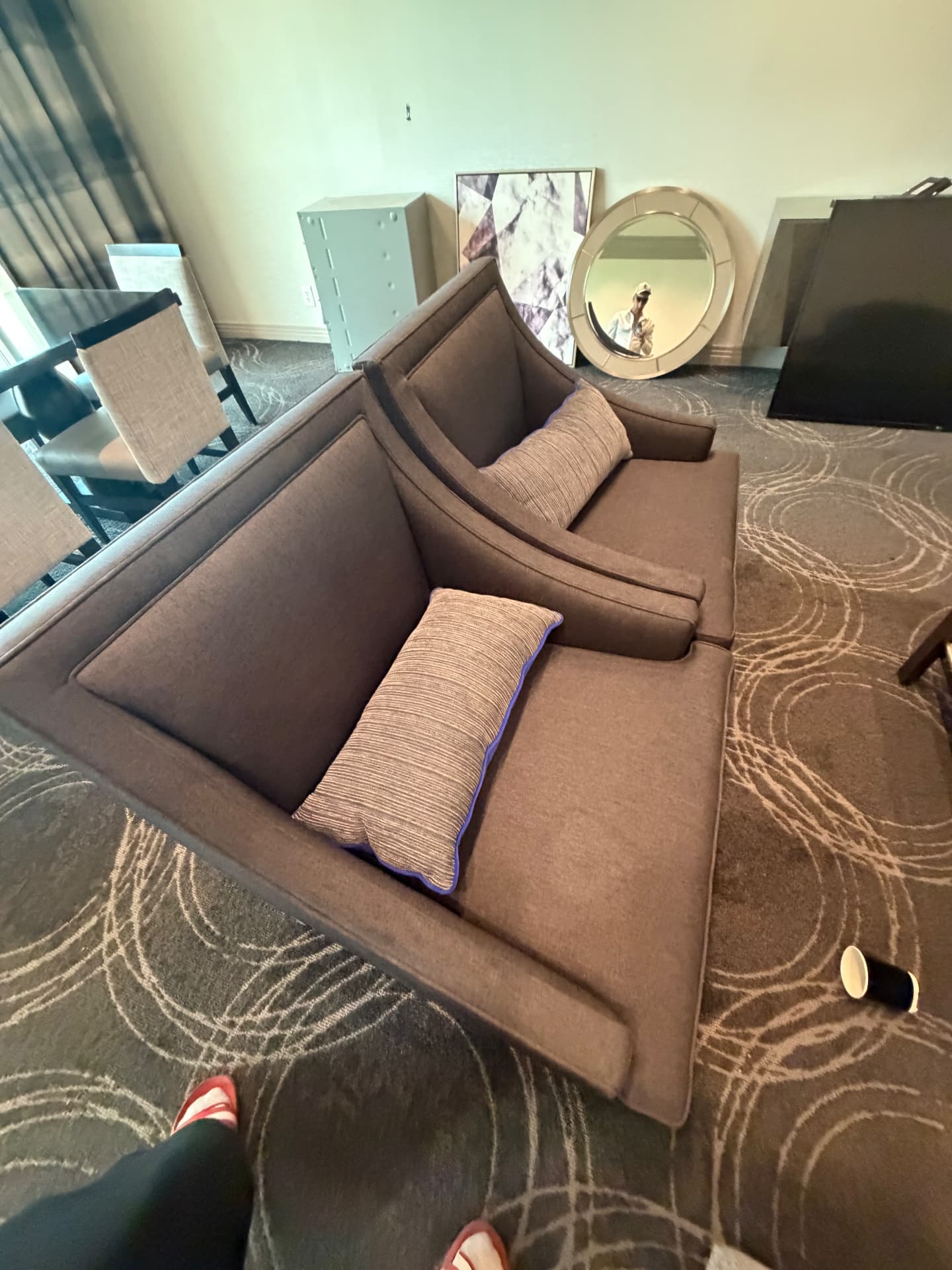Suite sectional sofa with bolster pillows, mirrored panels, round wall mirror and framed art