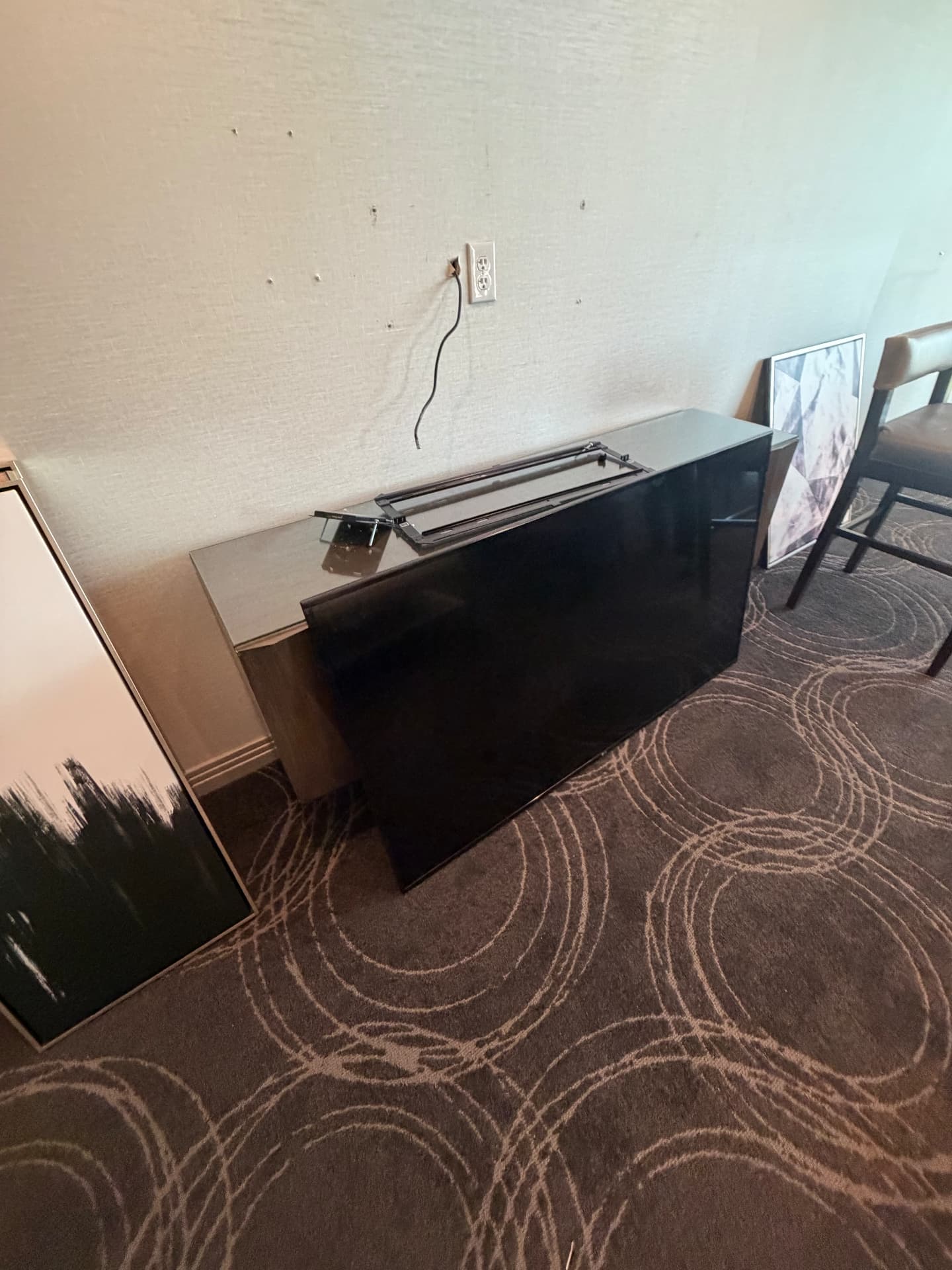Large flat-screen TV with wall mount, credenza and framed artwork staged for pickup