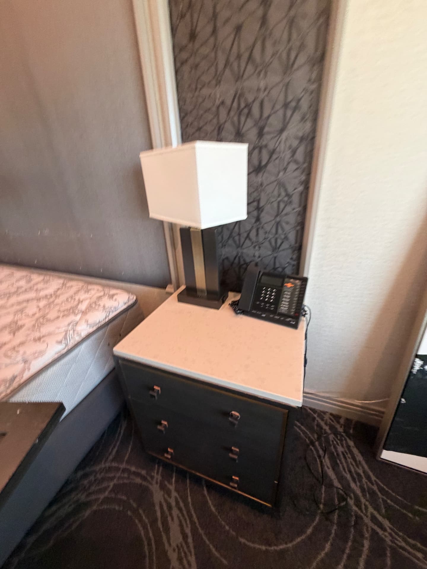 Suite nightstand with stone top, table lamp and multi-line telephone